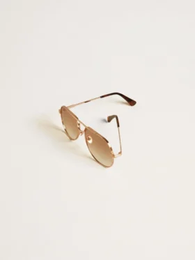 Aviator style sunglasses with rose-gold frame and honey-colored lenses