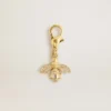 Bee-shaped charm in gold-colored brass with crystals