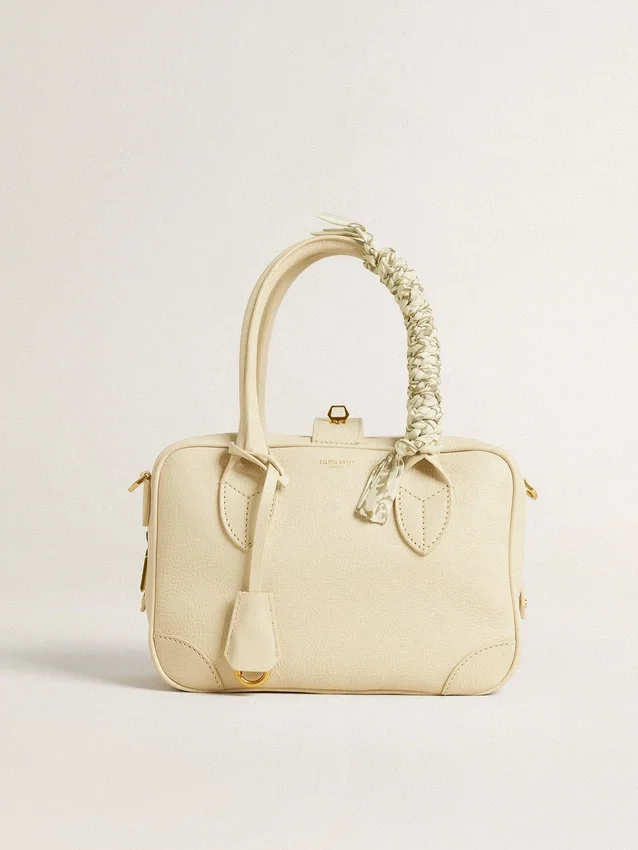 Butter-colored braided fabric charm with brass chain