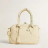 Butter-colored braided fabric charm with brass chain