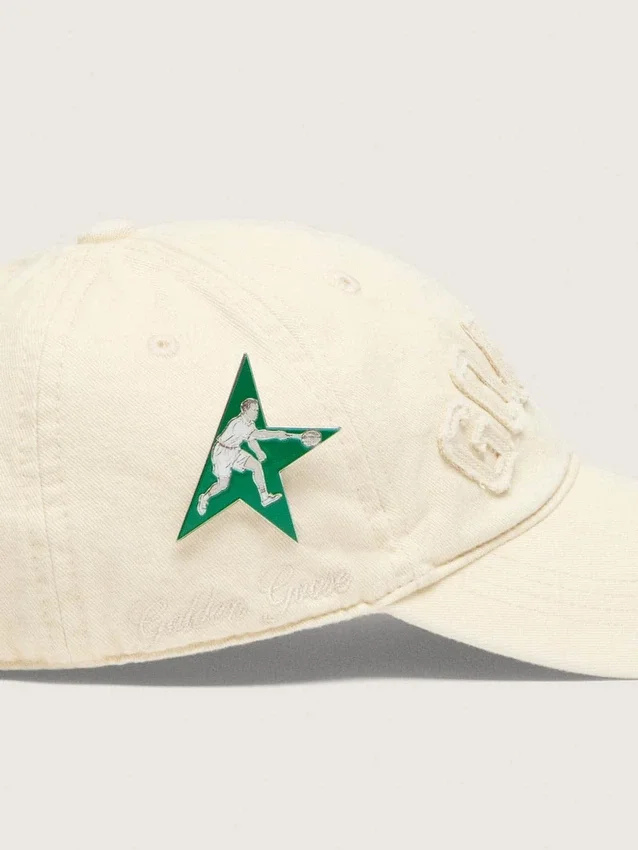 Cream baseball cap with tone-on-tone "Golden" patch and green star pin
