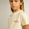 Girls' cotton T-shirt in worn white with red embroidery on the chest