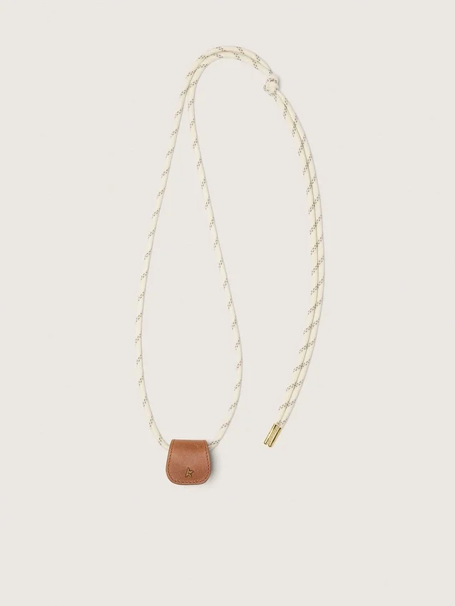 Glasses case with a cream-colored hiking strap and a tan-colored leather clip