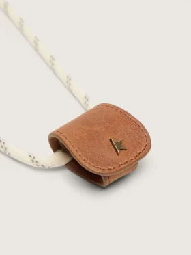 Glasses case with a cream-colored hiking strap and a tan-colored leather clip
