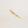 Gold-colored brass charm with Golden Goose signature