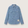 Journey unisex shirt in light blue cotton chambray with fringed hem and embroidered patch