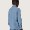 Journey unisex shirt in light blue cotton chambray with fringed hem and embroidered patch