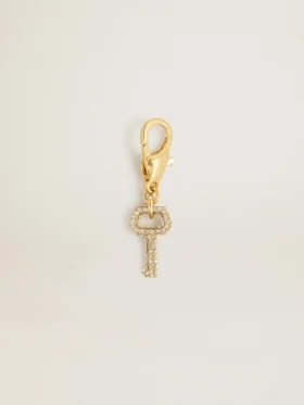 Key-shaped charm in gold-colored brass with crystals