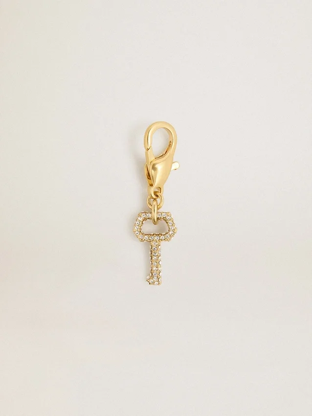Key-shaped charm in gold-colored brass with crystals