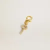 Key-shaped charm in gold-colored brass with crystals