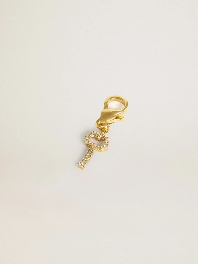 Key-shaped charm in gold-colored brass with crystals