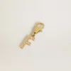Letter F charm in gold-colored brass with crystals