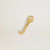 Letter J charm in gold-colored brass with crystals