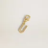 Letter U charm in gold-colored brass with crystals
