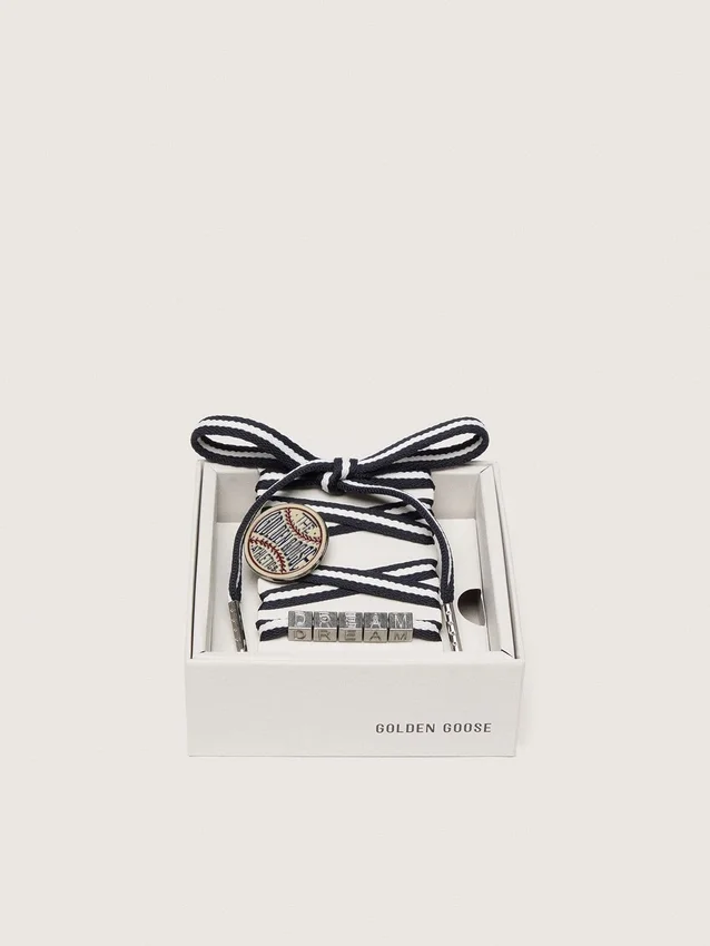 Skins cream and dark blue striped laces with pin and silver appliqué