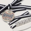 Skins cream and dark blue striped laces with pin and silver appliqué