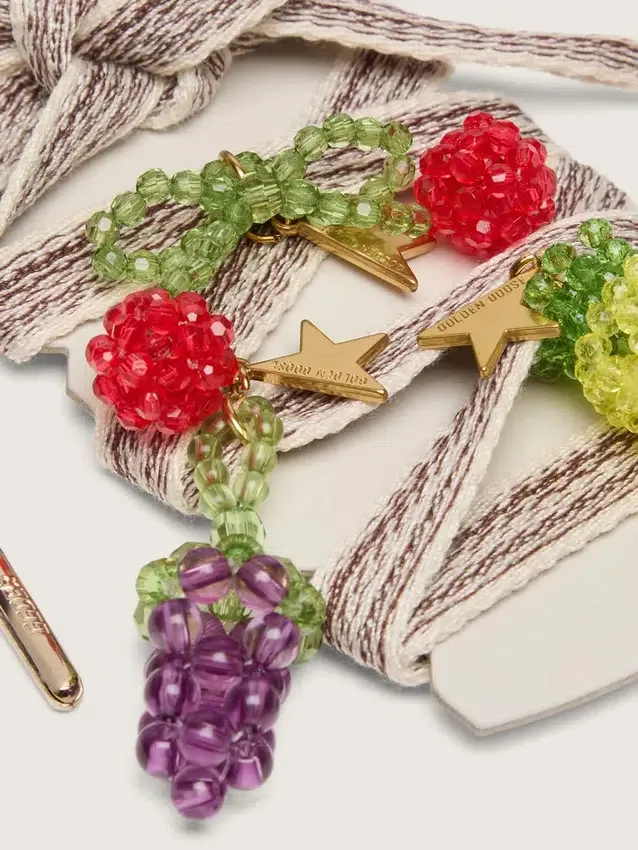Skins cream and dove-gray striped embroidered laces with three fruit beaded charms