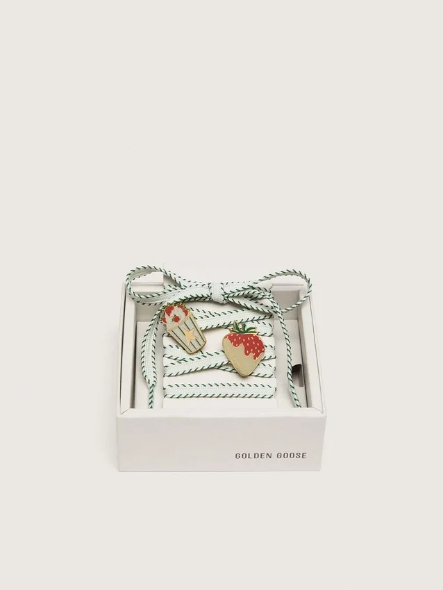 Skins white laces with forest-green embroidery and strawberry pins
