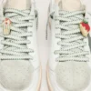 Skins white laces with forest-green embroidery and strawberry pins