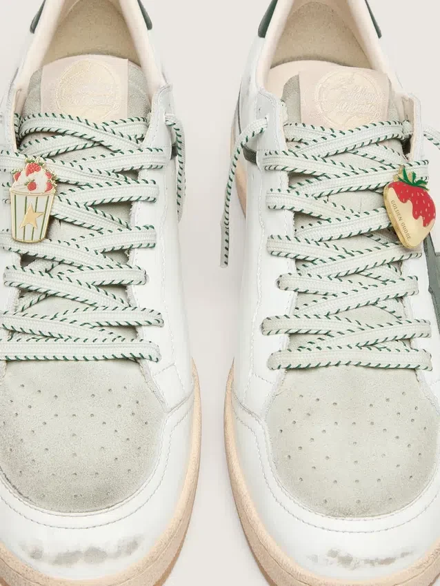 Skins white laces with forest-green embroidery and strawberry pins