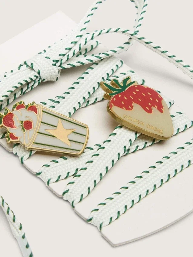 Skins white laces with forest-green embroidery and strawberry pins
