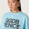 Women’s cropped T-shirt in light blue cotton jersey with graphic print