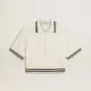Women's cropped worn-white cotton polo shirt with blue ribbing