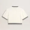 Women's cropped worn-white cotton polo shirt with blue ribbing