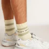Worn-white socks with distressed details and sage-green stripes